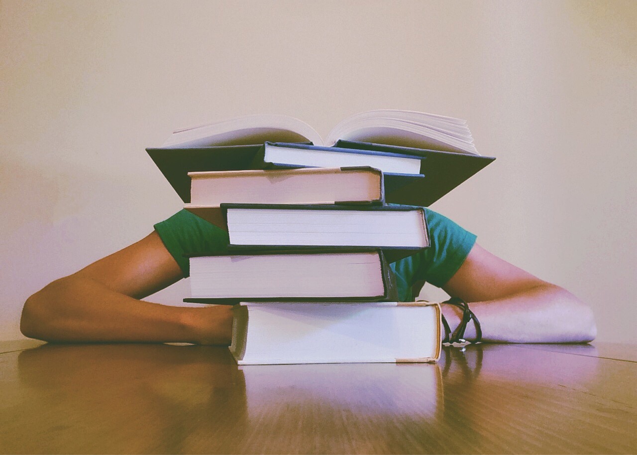 Student studying research materials at a university library desk
