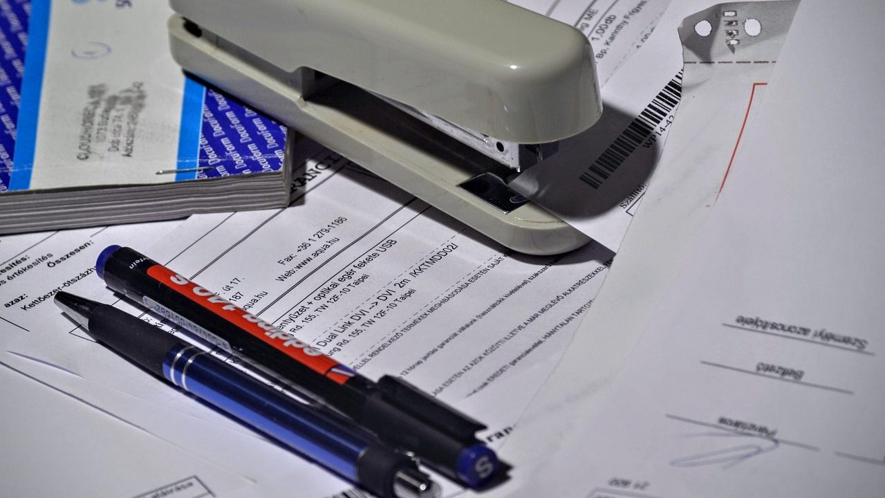 Freelancer reviewing workspace invoice at a desk