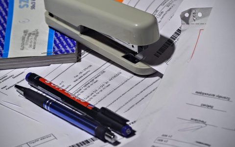 Freelancer reviewing workspace invoice at a desk