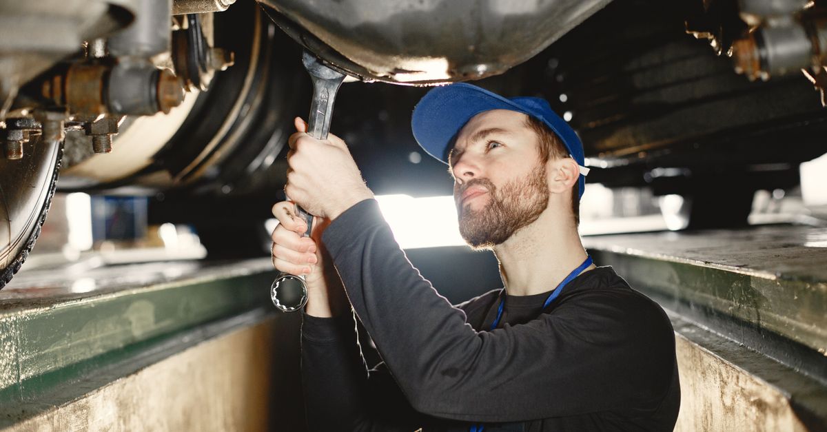 A close-up view of a trailer suspension and wheel axle being examined for wear.