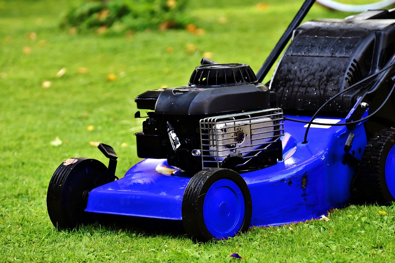 Checking the underside of a riding lawn mower deck for rust and blade damage.