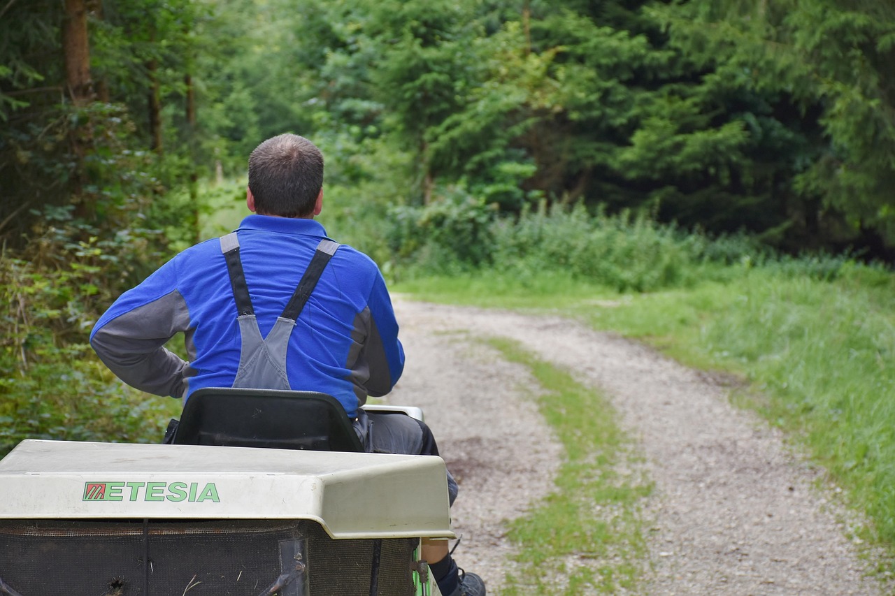 Operating a riding lawn mower across a suburban lawn during a test drive.