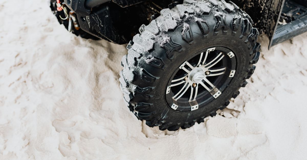 Close-up of heavy-duty utility vehicle tires and suspension components.