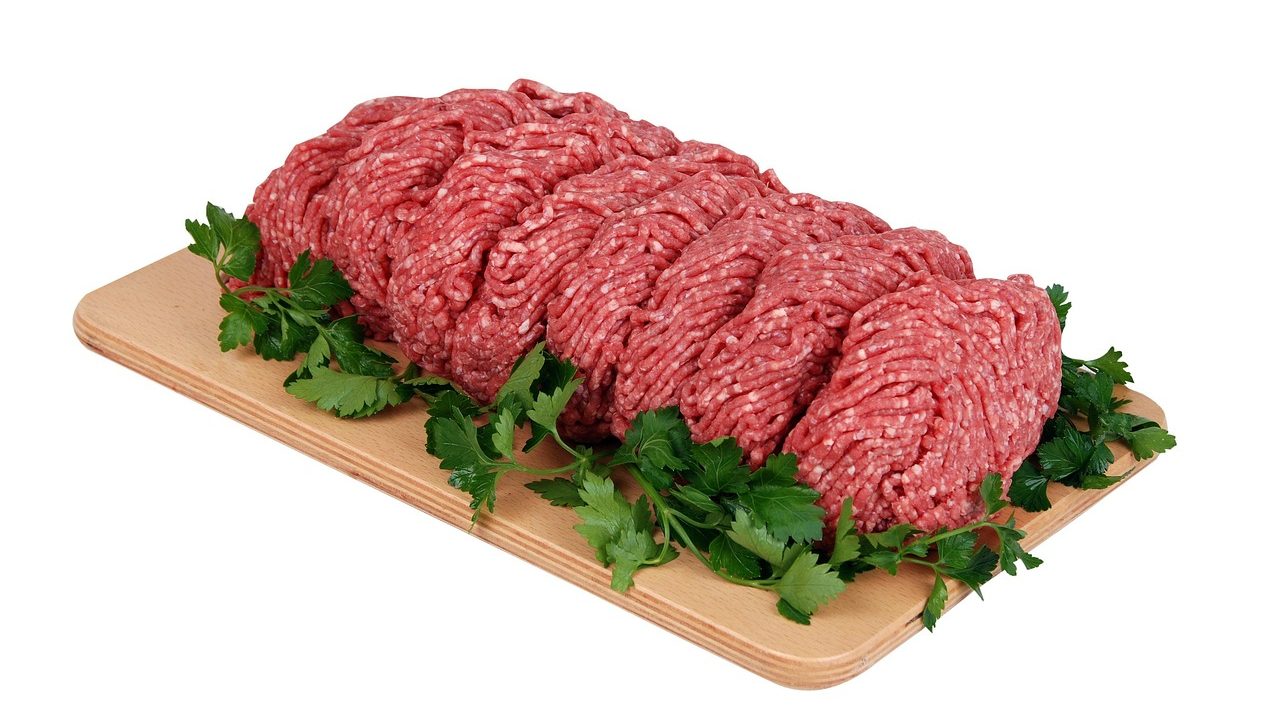 Organizing wrapped cuts of beef in a deep chest freezer.