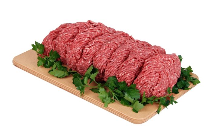 Organizing wrapped cuts of beef in a deep chest freezer.