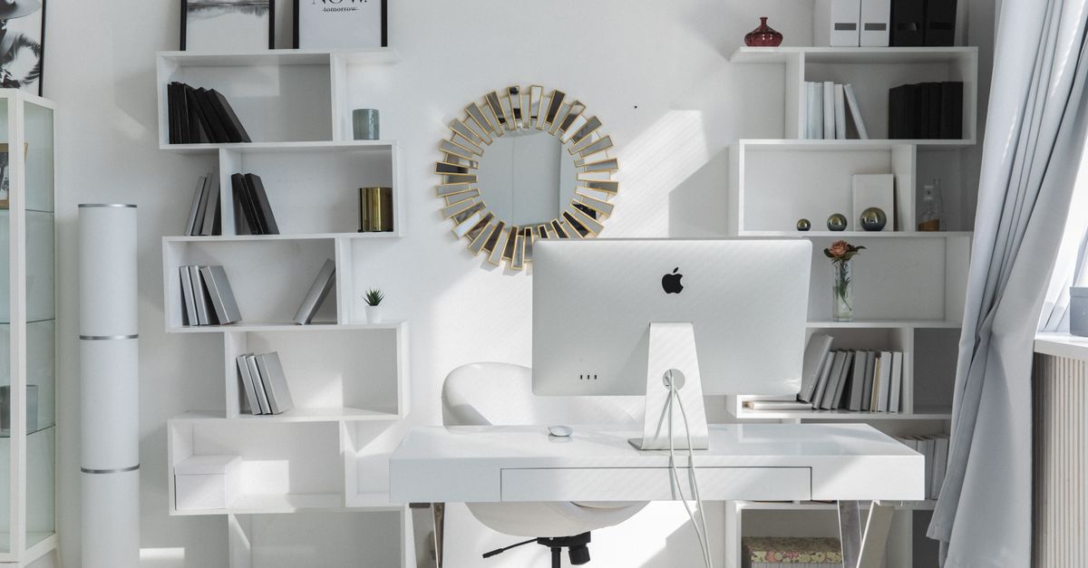 Remote worker organizing a minimalist home office desk with a synthetic desk pad.