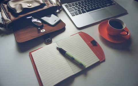 A clean home office setup featuring a large leather desk mat, keyboard, and mouse.