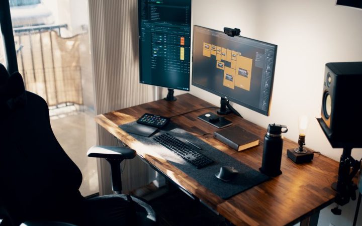 A clean wooden monitor shelf riser placed on a modern desktop holding a computer screen.