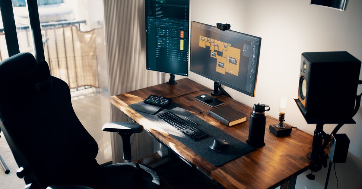 A clean wooden monitor shelf riser placed on a modern desktop holding a computer screen.
