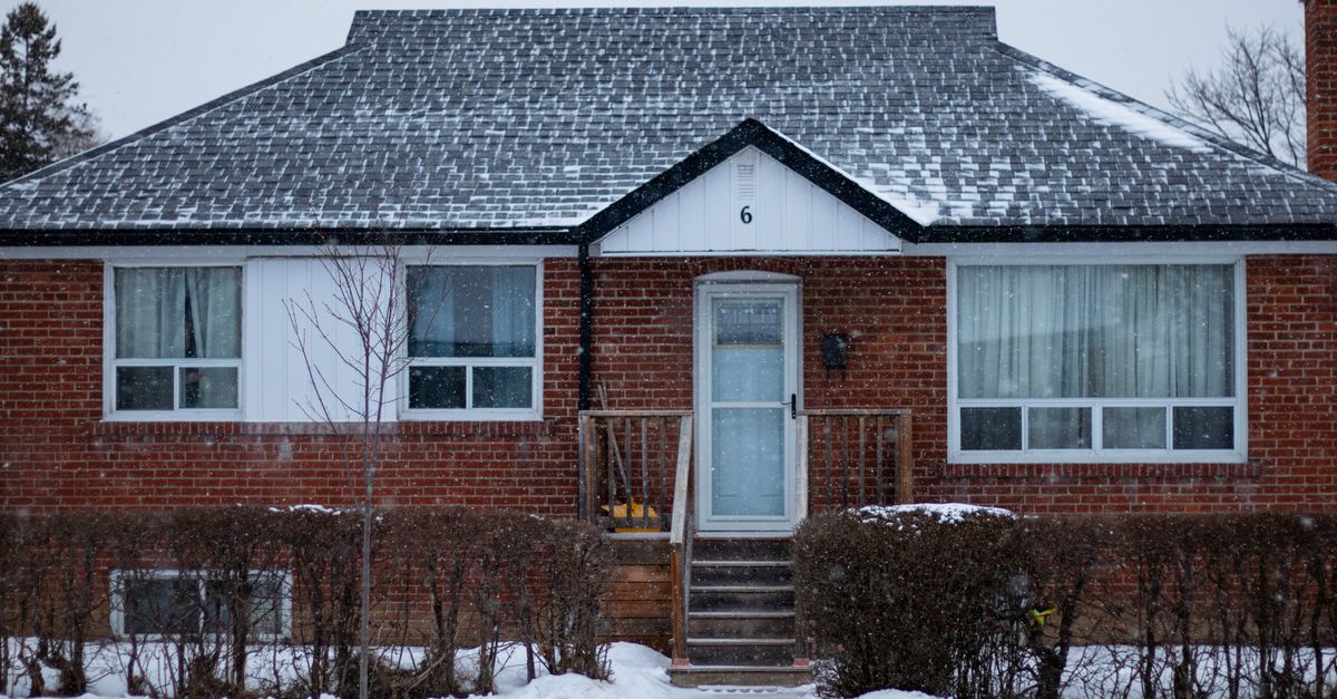 Snow-covered residential house exterior with modern insulated windows