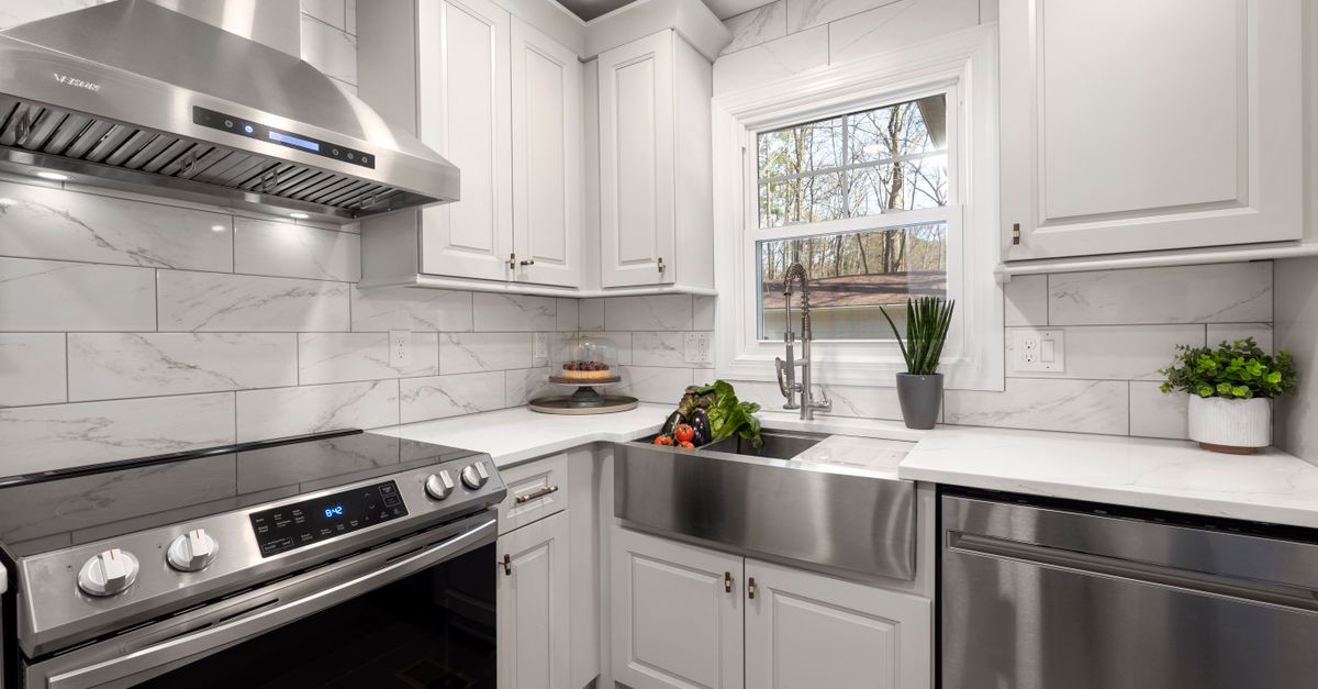 Professional stainless steel overhead range hood mounted above a gas cooktop.
