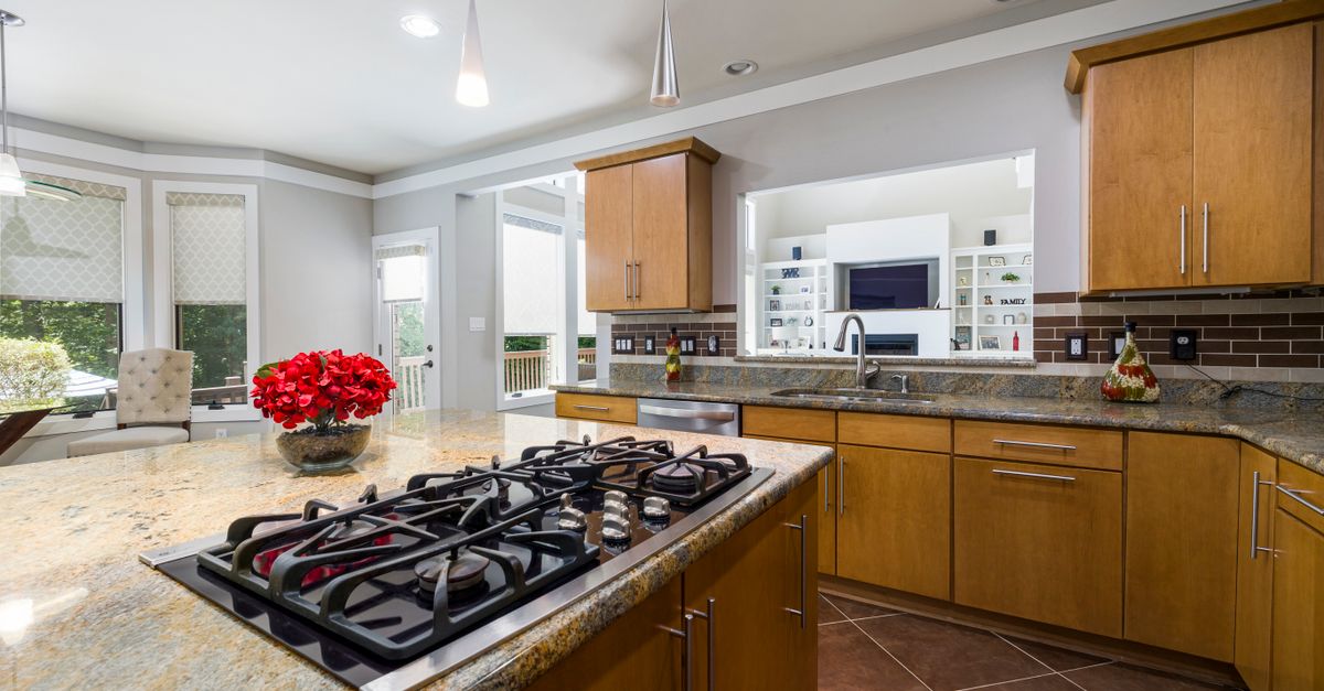 Sleek modern kitchen island featuring a glass cooktop and stainless steel appliances.
