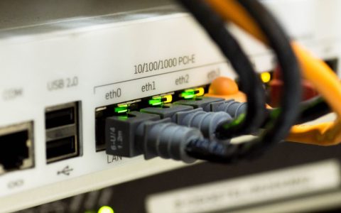 Close-up of network router and ethernet cables plugged into a home office switch.