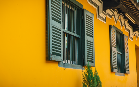 A modern home featuring clean exterior security shutters installed on lower-level windows.