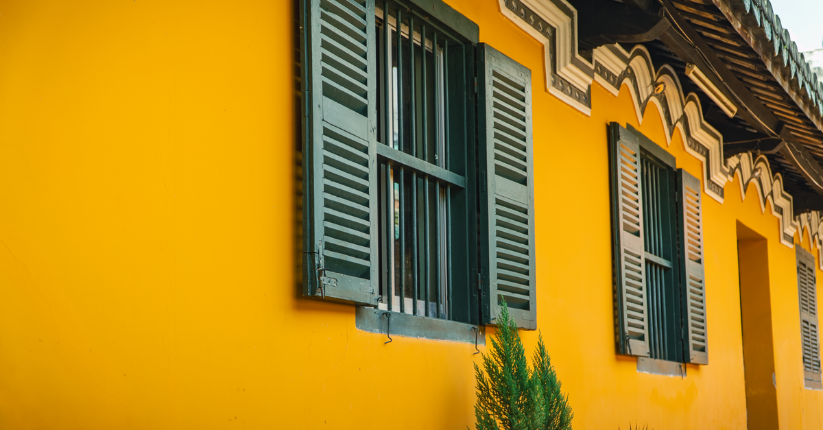 A modern home featuring clean exterior security shutters installed on lower-level windows.