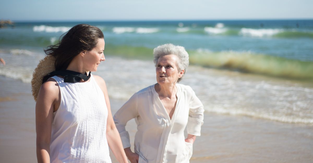 An adult daughter talking with her aging mother in a living room.