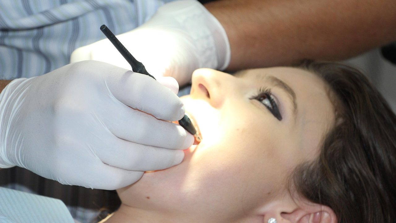 Orthodontist examining a young patient in a dental chair
