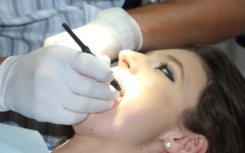 Orthodontist examining a young patient in a dental chair