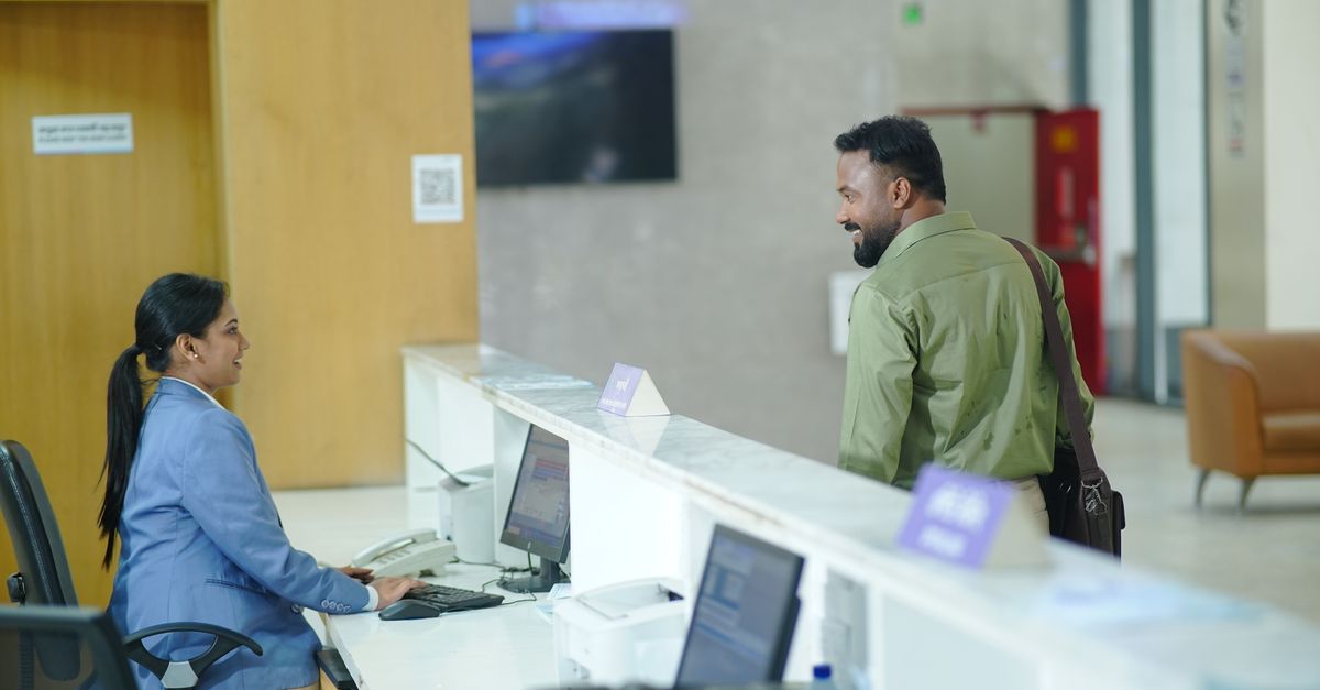 Librarian assisting a visitor at a public library service counter