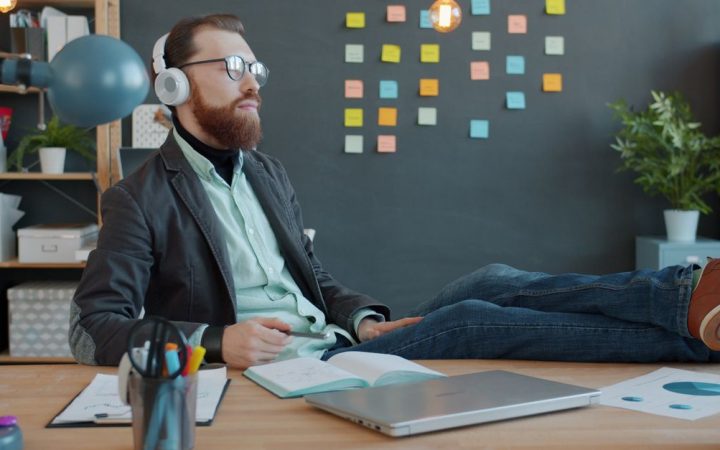Remote professional working on a laptop at a home desk setup with notes and coffee