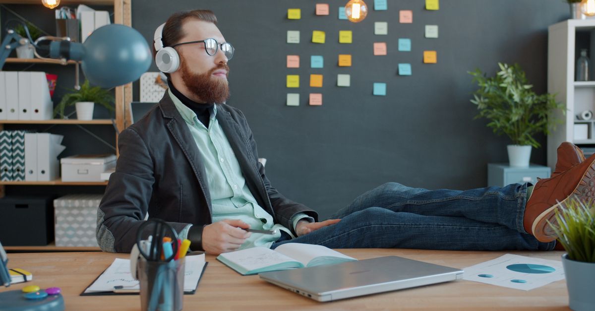 Remote professional working on a laptop at a home desk setup with notes and coffee
