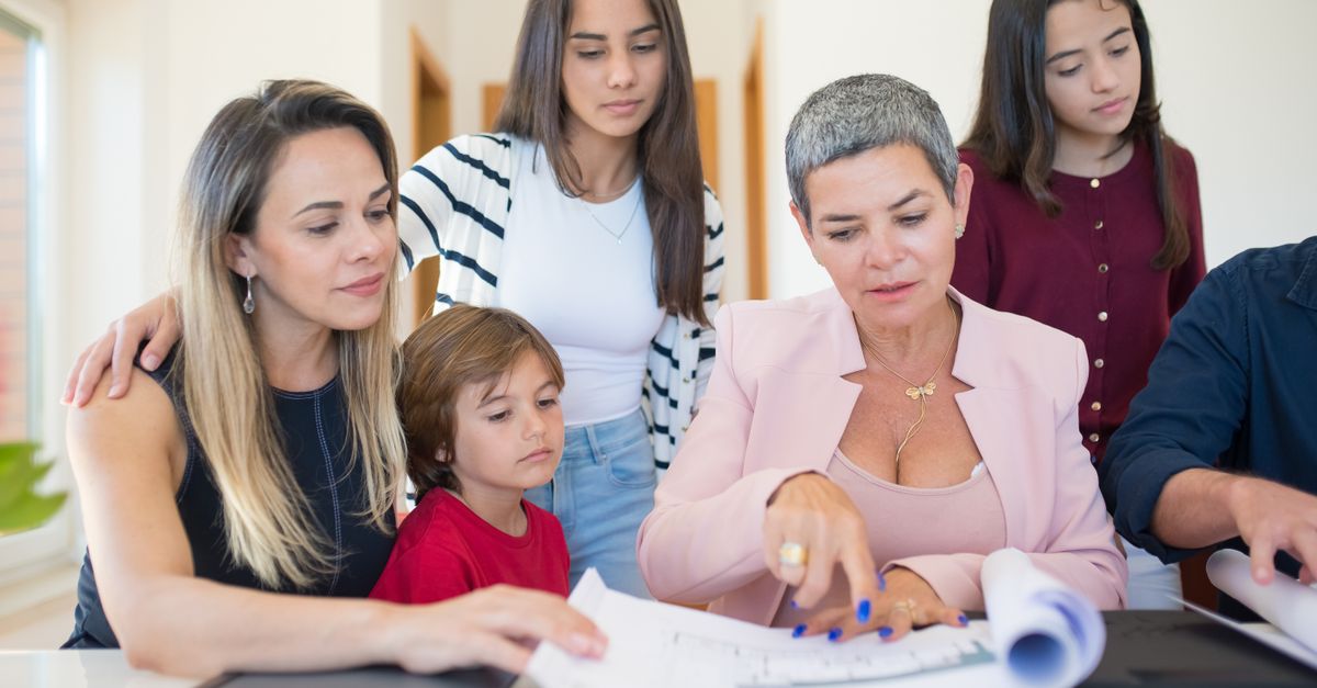 Parent and high school student sitting at a kitchen table reviewing course catalog and schedule together