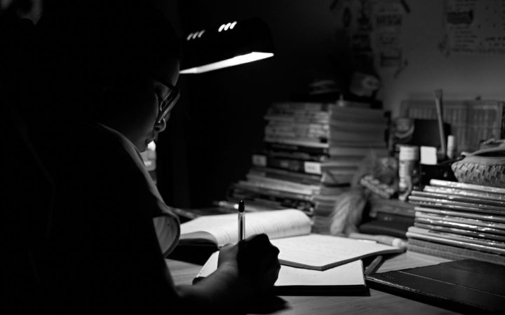 High school student organizing application paperwork at a desk