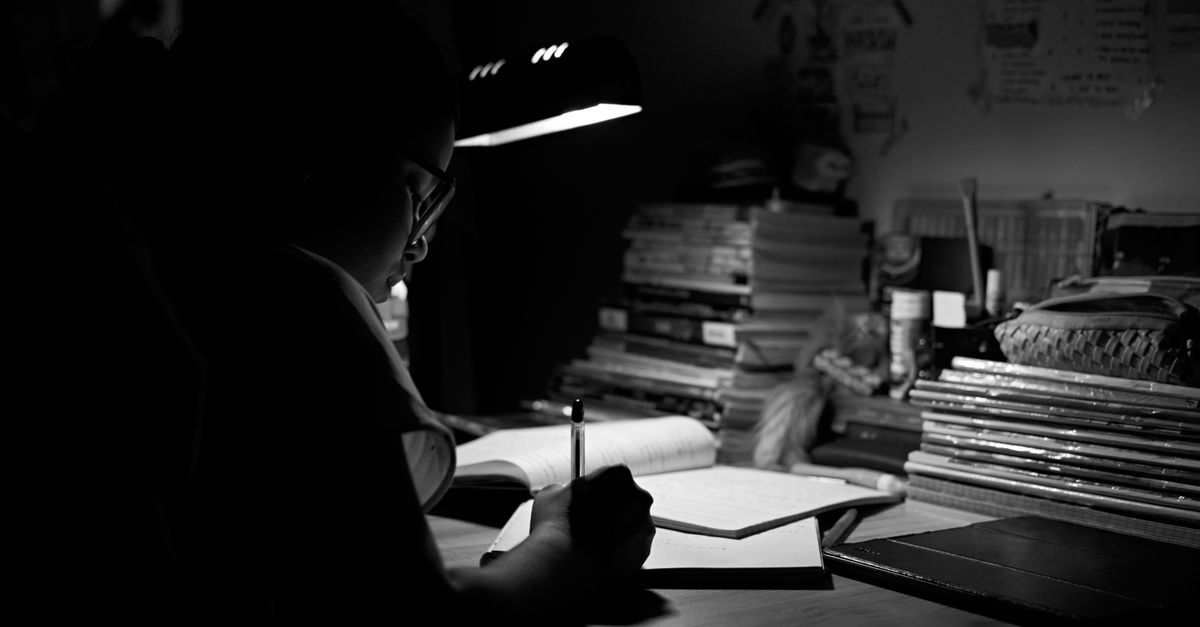 High school student organizing application paperwork at a desk