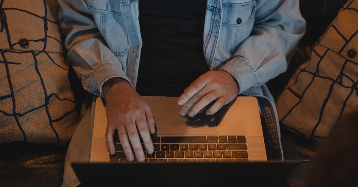 A close-up of hands typing numbers into a home spreadsheet.