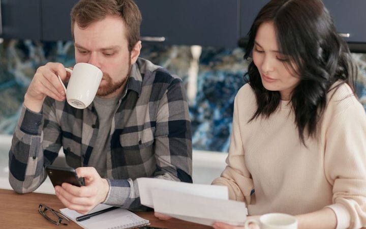 Suburban homeowner reviewing a monthly utility bill at a kitchen table