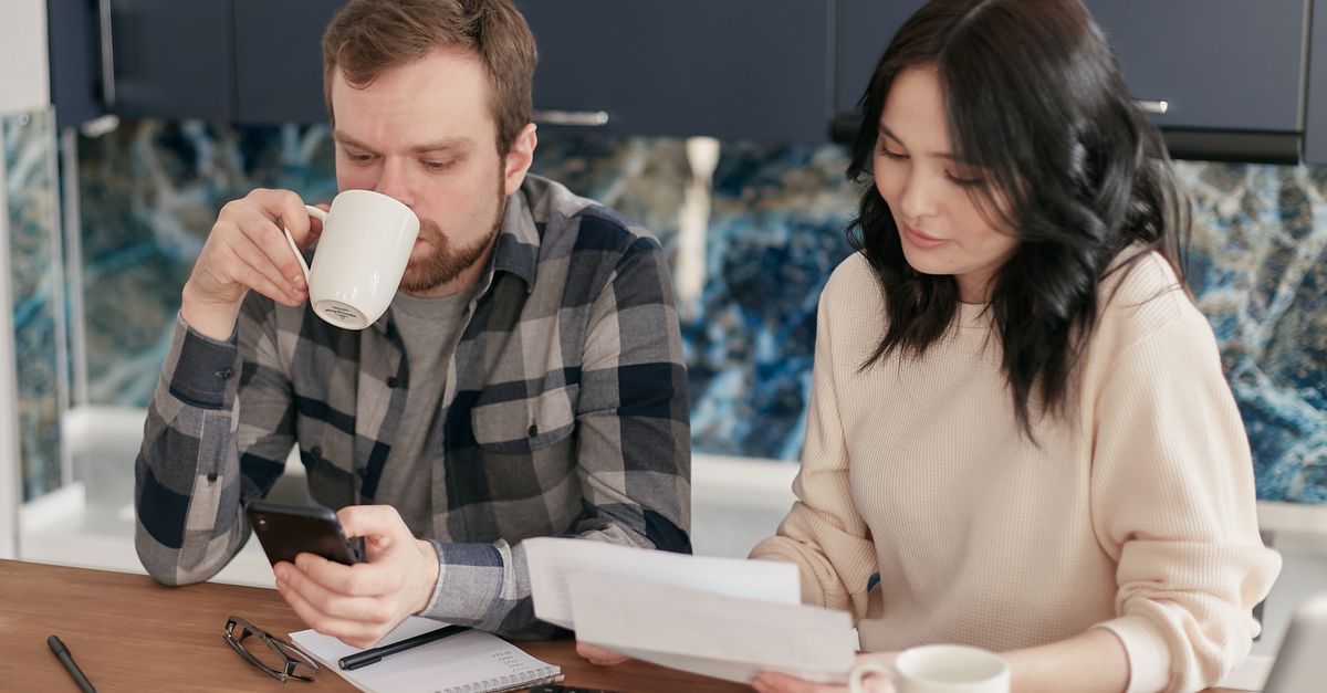 Suburban homeowner reviewing a monthly utility bill at a kitchen table