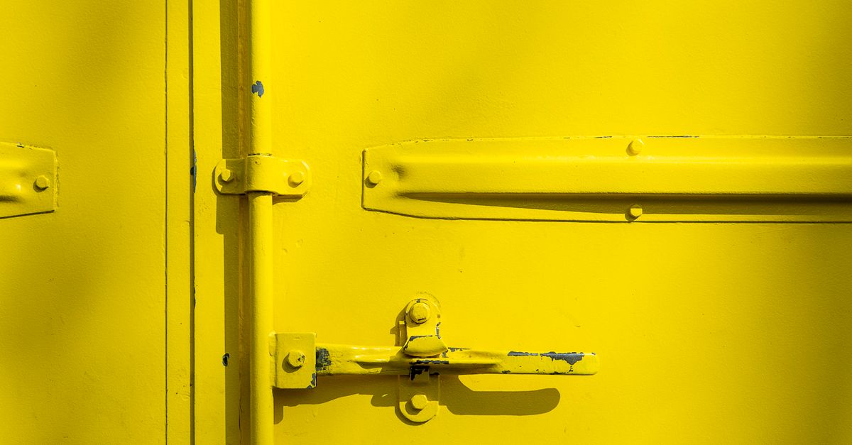 Detailed view of an exterior storm door latch mechanism and strike plate.