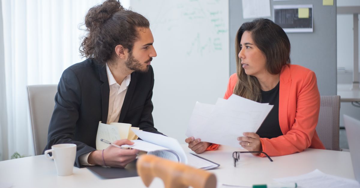 Two colleagues having a serious professional discussion in an office conference room.