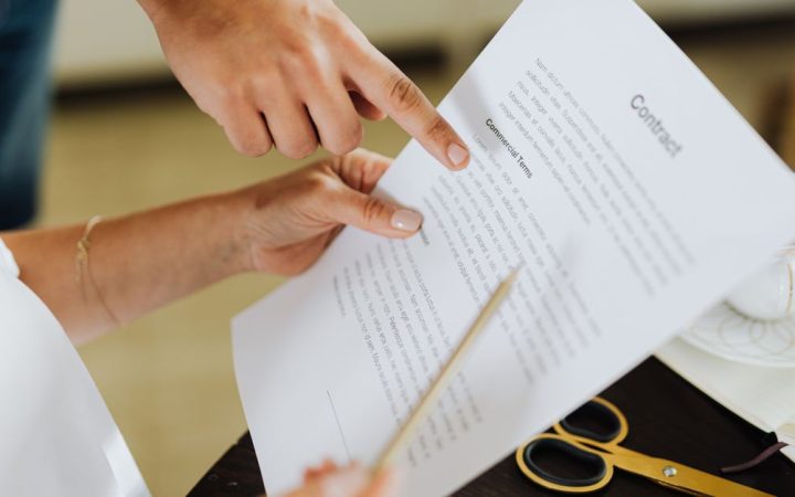 Corporate professional reviewing a compensation contract at a wooden desk.
