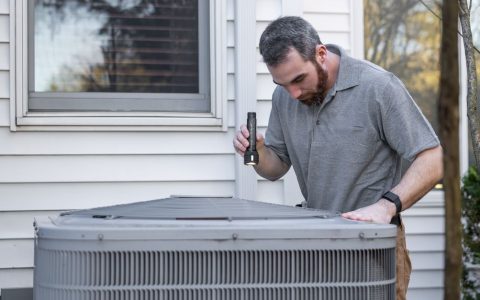 HVAC technician inspecting a residential ventilation system in a utility room