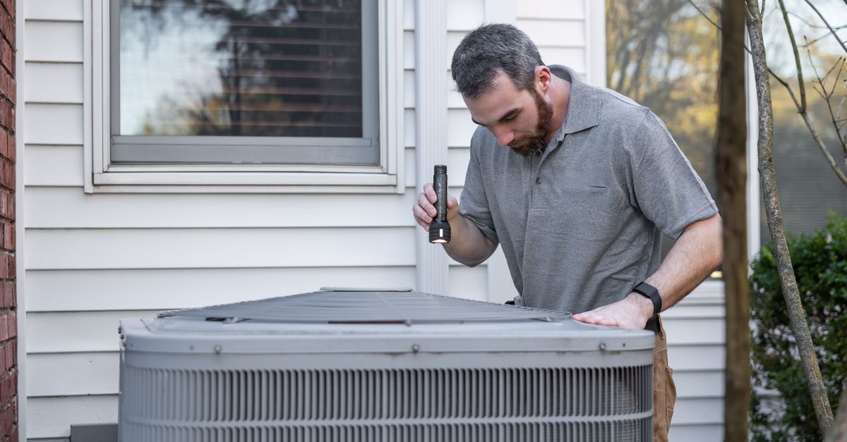 HVAC technician inspecting a residential ventilation system in a utility room