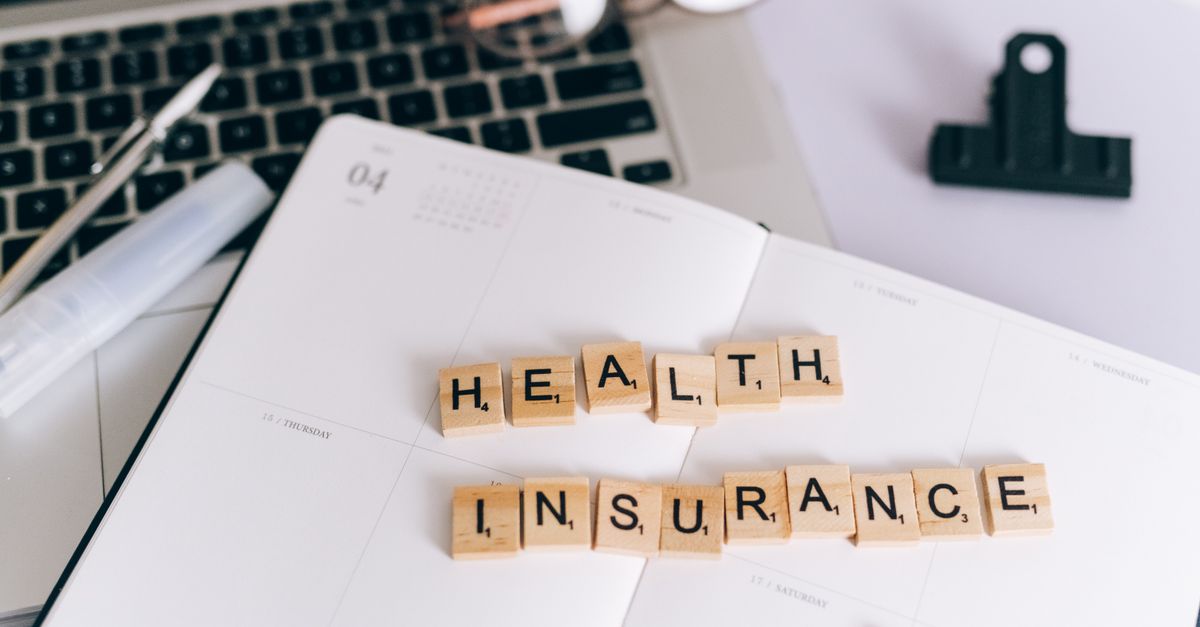 Close up of health insurance policy documents and a pen on a desk