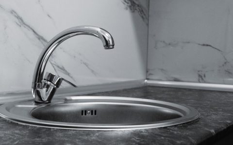 Close-up of a modern kitchen tap with an instant hot water dispenser handle.