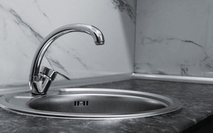 Close-up of a modern kitchen tap with an instant hot water dispenser handle.