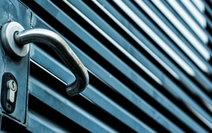 Close-up of a person using a screwdriver to fix an interior door lockset