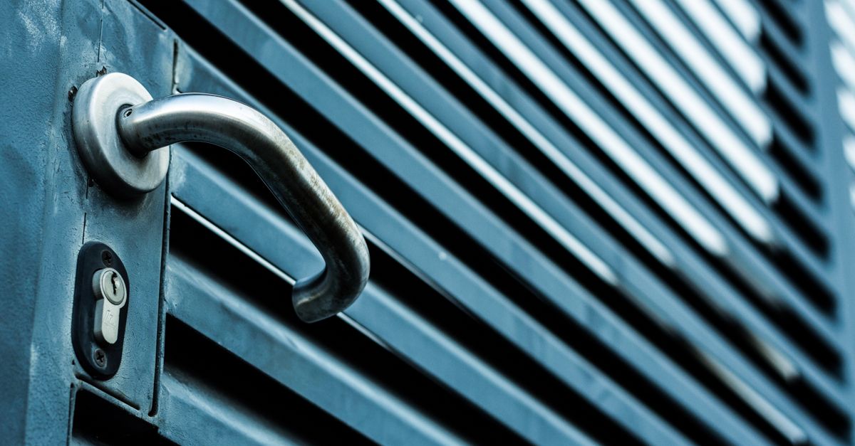 Close-up of a person using a screwdriver to fix an interior door lockset