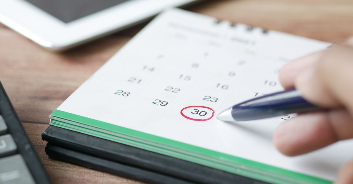 Parent reviewing a birthday party planning calendar and checklist at a wooden table