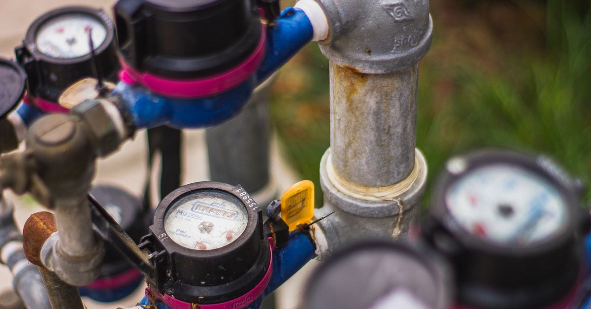 A plumber checking water pressure in a residential bathroom.