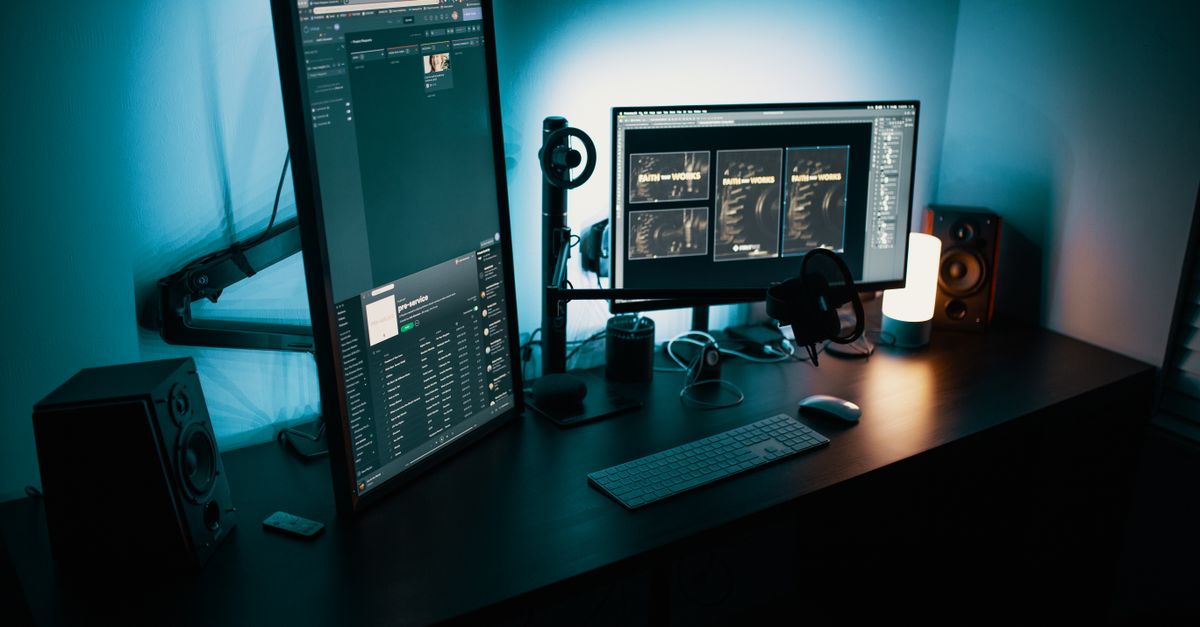Remote worker adjusting a monitor mounting arm to align screen heights.