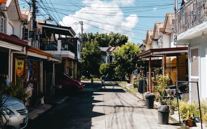 A clean, well-maintained mobile home community street under a bright daytime sky.