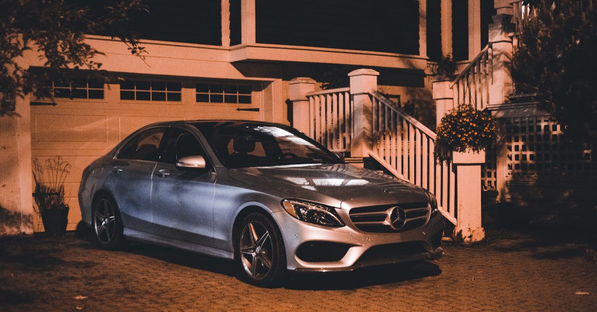 A sedan parked in the driveway of a residential suburban home.