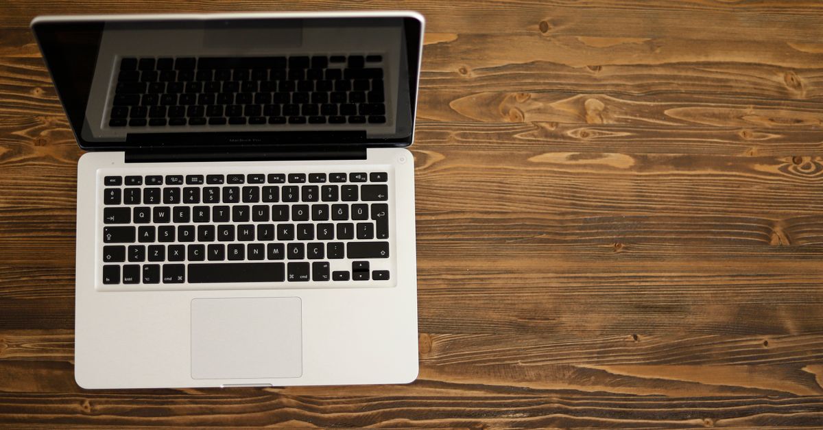 Open laptop displaying a code or text editor with clean typography on a minimalist desk.