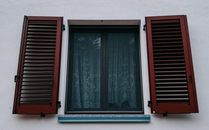 Close-up of solid wood plantation shutters installed inside a bright living room window.