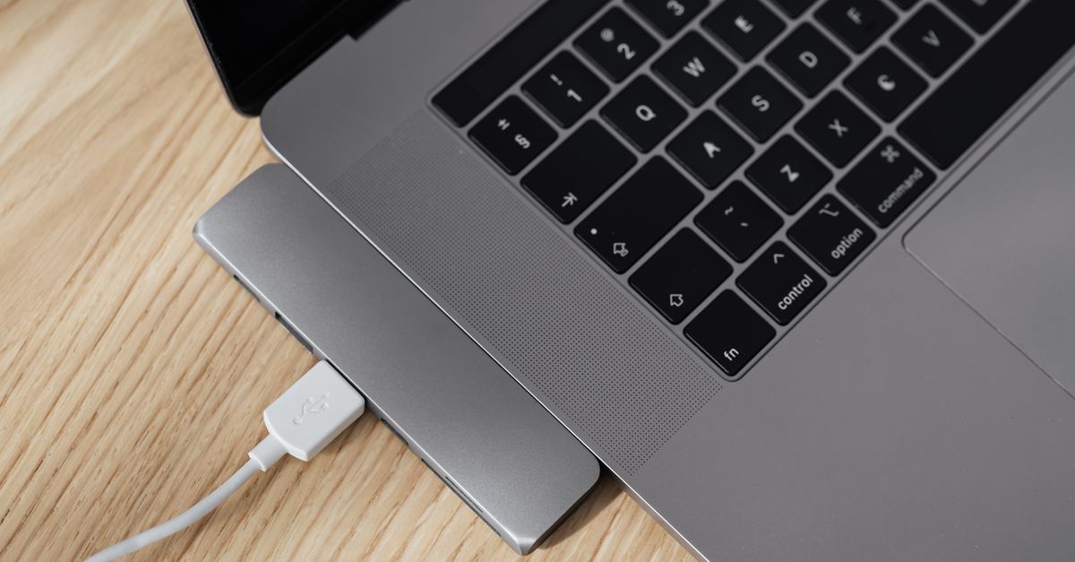 Close-up of USB-C cables and hubs connected to a laptop.