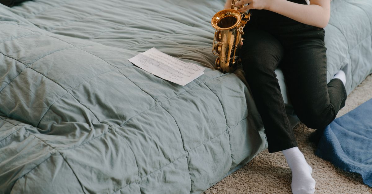 Student holding a rental saxophone in a music store